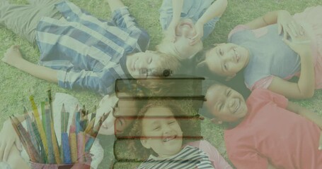 Canvas Print - Animation of stack of books moving over happy school children lying on grass