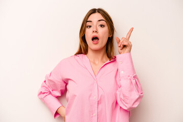 Young caucasian woman isolated on white background pointing upside with opened mouth.