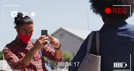 Poster - Video of play screen over diverse man and woman wearing face masks and taking selfie