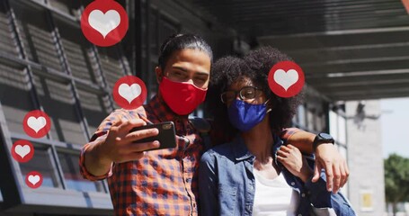 Poster - Video of falling icons over diverse man and woman wearing face masks and using technology