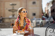 © rh2010 - Woman eating italian pasta and drinking wine at restaurant on the street in Rome. Concept of Italian gastronomy and travel. Stylish woman with sunglasses and colorful hair shawl