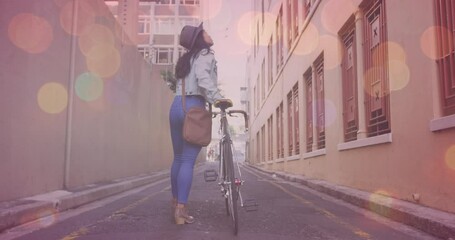 Poster - Animation of light spots over asian woman walking with bicycle