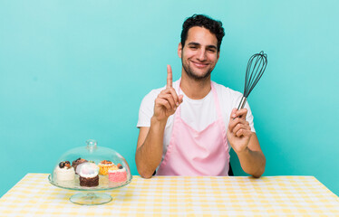 Wall Mural - hispanic handsome man smiling proudly and confidently making number one. home made cakes cocnept