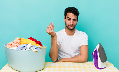 hispanic handsome man making capice or money gesture, telling you to pay iron and clothes concept