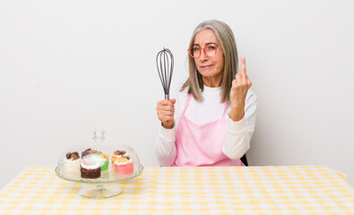 senior  gray hair woman feeling angry, annoyed, rebellious and aggressive. homemade cakes concept