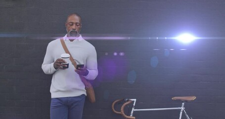 Poster - Animation of light spots over african american man using smartphone