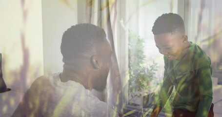 Poster - Animation of grass over happy african american father and son having fun at home