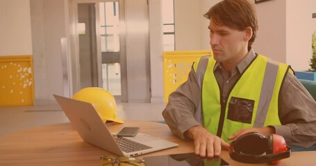 Poster - Animation of caucasian male worker using laptop and tablet in office
