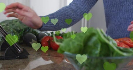 Sticker - Animation of hearts over caucasian man cooking and using tablet