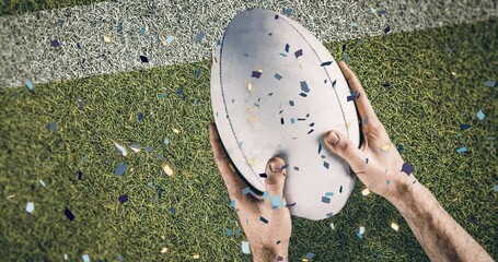 Poster - Animation of confetti over caucasian male rugby player with ball at stadium