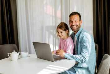 Wall Mural - Father and daughter using laptop computer together