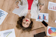 © shunevich - Attractive female freelancer or student stretching while working or studying, sitting on the floor at home. Young business woman making financial report or presentation, take a little break for rest
