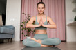 © tgordievskaya - Yoga session at home concept. Lotus position or Padmasana for to calm the mind and prepare the practitioner for deep meditation. Woman with eyes closed practicing breathing exercise.