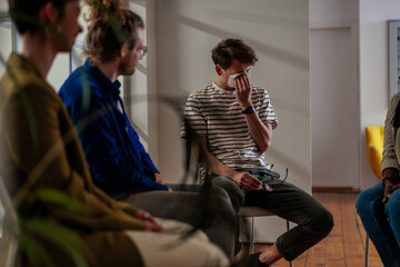 Wall Mural - Crying young man in support group