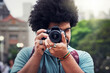 © AS/peopleimages.com - Capturing the city his way. Shot of a young man taking pictures with a camera in the city.