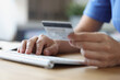 © megaflopp - Person holds credit bank card and computer keyboard