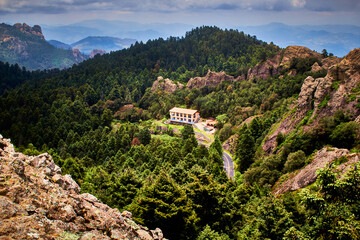 Wall Mural - casa grande o mansion entre las montañas y un gran bosque verde con un cielo nublado en mineral del chico hidalgo 