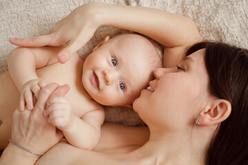 Wall Mural - a naked mother and the baby on the bed. maternal and child health. 