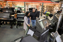 Worker And Customer Looking At Grills In Barbeque Store