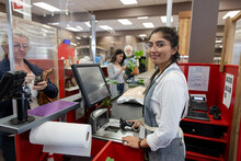 Portrait Of Cheerful Cashier At Checkout