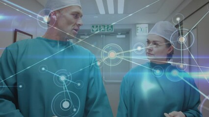 Wall Mural - Animation of network of connections over caucasian female and male surgeons talking