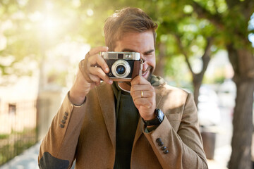 Poster - Say cheese. Cropped shot of a handsome young man taking photographs during his morning commute.