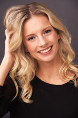 Sweet and beautiful. Portrait of a beautiful young blonde woman smiling sweetly in studio.