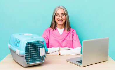 Wall Mural - senior gray hair woman smiling happily with a hand on hip and confident. veterinarian concept