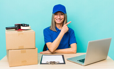 Wall Mural - senior gray hair woman smiling cheerfully, feeling happy and pointing to the side. employee packer concept