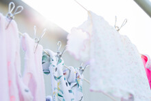 Baby Clothes Drying On Clothesline Pegged Up With Metal Clothes Pegs