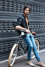 Hes Definitely A Trendsetter. Full Length Shot Of A Handsome Young Man Sitting On A Bicycle Outdoors.
