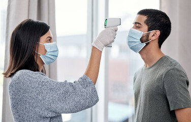 Poster - Stay one step ahead of sickness with consistent symptom management. Shot of a young woman taking her husbands temperature while recovering from an illness at home.