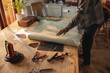 © Wavebreak Media - Low section of young african american craftsman touching leather on workbench in workshop