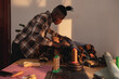 © Wavebreak Media - Side view of african american young craftsman choosing leather on workbench in workshop