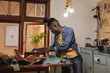 © Wavebreak Media - African american young craftsman using laptop while working at workbench in leather workshop