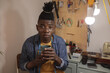 © Wavebreak Media - Portrait of african american young craftsman with eyeglasses and dreadlocks holding coffee cup