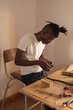 © Wavebreak Media - African american young craftsman attaching buckle on leather belt while working in workshop