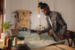 © Wavebreak Media - African american young craftsman keeping leather on workbench while working in workshop