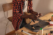 © Wavebreak Media - Midsection of african american young craftsman burning thread while making belt in workshop