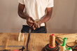 © Wavebreak Media - Midsection of african american young male craftsperson fixing buckle on leather belt in workshop
