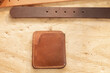 © Wavebreak Media - High angle view of leather belt and wallet on wooden table in workshop