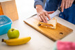 © Wavebreak Media - Midsection of caucasian mature woman cutting sandwich for lunch box
