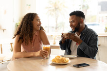 African American Young Couple Enjoying Coffee While Talking At Cafe