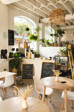 Menus On Chalkboards Amidst Furniture In Modern Coffee Shop