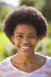 © Wavebreak Media - Portrait of happy teenage girl with afro hairstyle in backyard on sunny day