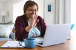 © Wavebreak Media - Happy senior african american woman waving hand on laptop during online doctor consultation at home