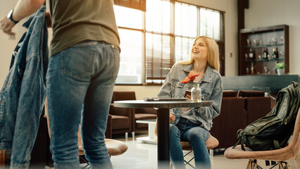 Young traveler lover couple siting on terminal chair seat with luggage suitcase, laughing and having fun times together.