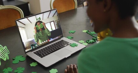 Poster - Smiling african american woman wearing clover shape items on video call on laptop