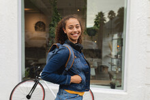 Portrait Of Smiling Young African American Woman With Hand In Denim Jacket Pocket