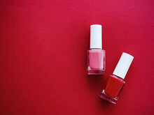 Red And Pink Nail Polish Bottles On Red Background, Manicure And Beauty Cosmetics
